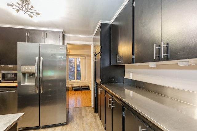 kitchen featuring crown molding, light hardwood / wood-style floors, a notable chandelier, and appliances with stainless steel finishes