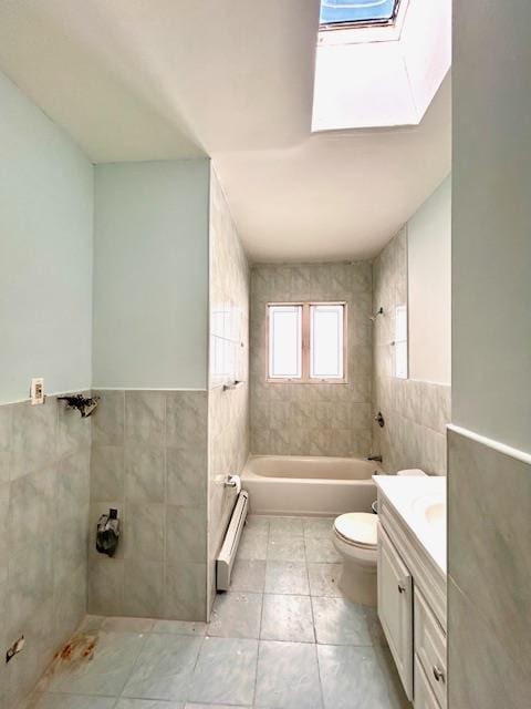 full bathroom featuring a skylight, tiled shower / bath combo, toilet, tile walls, and baseboard heating