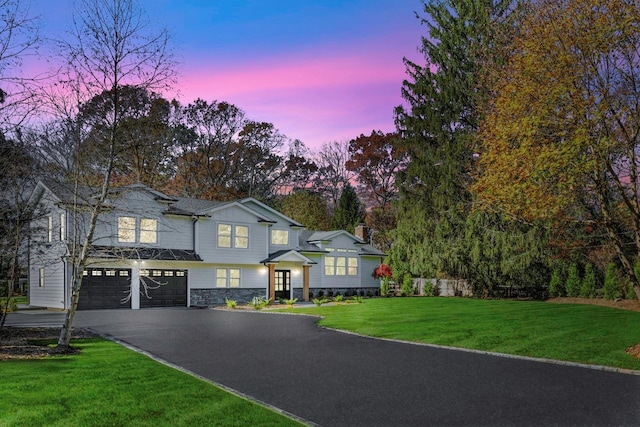 view of front facade featuring a garage and a lawn