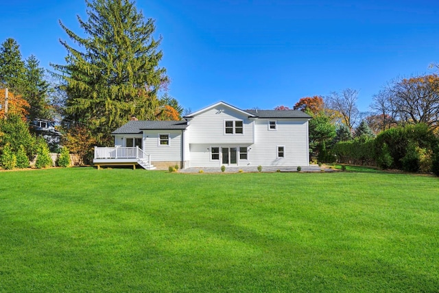 rear view of house with a deck and a yard