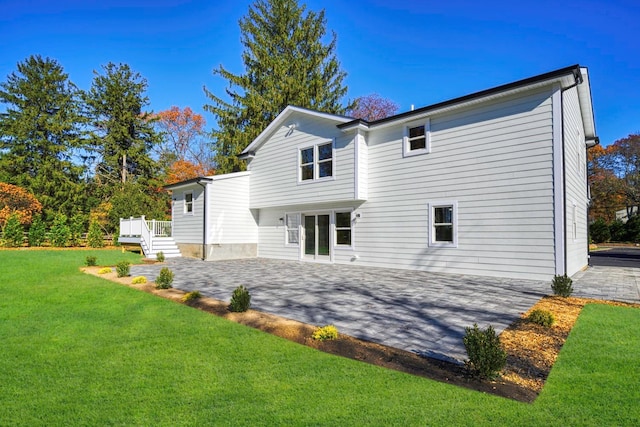 back of house with a wooden deck, a patio area, and a yard