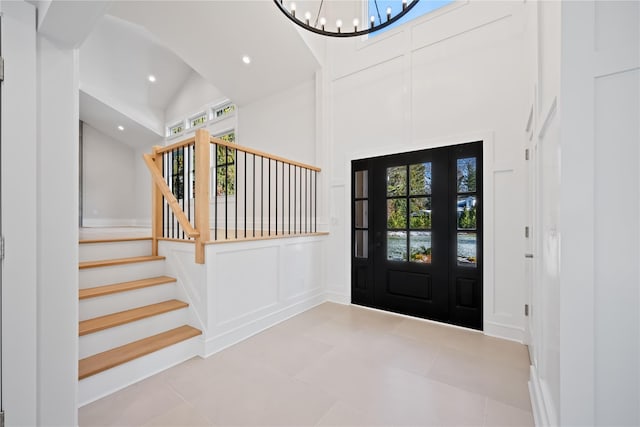 tiled foyer entrance featuring high vaulted ceiling