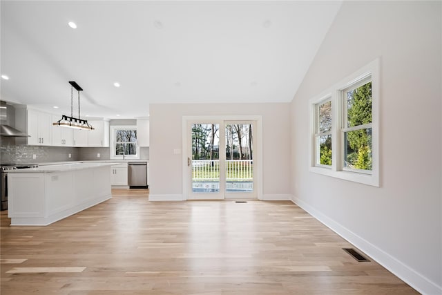 unfurnished living room featuring light hardwood / wood-style floors and lofted ceiling