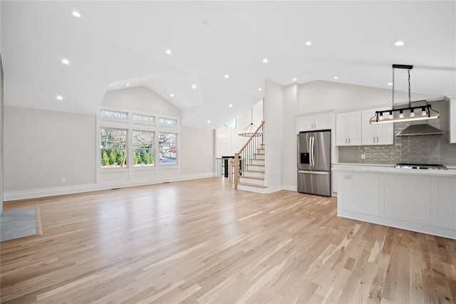 unfurnished living room with lofted ceiling and light wood-type flooring