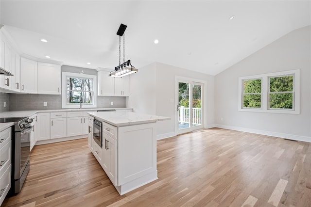 kitchen featuring a center island, white cabinets, stainless steel appliances, and plenty of natural light