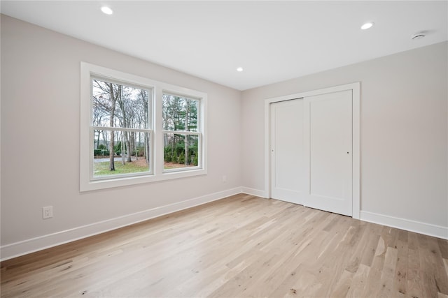 unfurnished bedroom with a closet and light hardwood / wood-style flooring