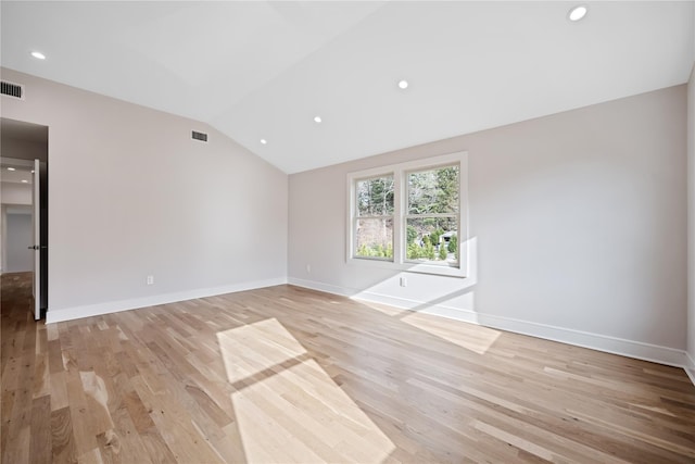 spare room with light hardwood / wood-style floors and lofted ceiling