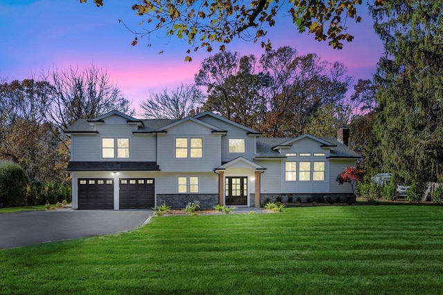 view of front of property with a yard, french doors, and a garage