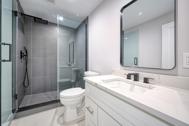 bathroom featuring tile patterned flooring, vanity, toilet, and an enclosed shower