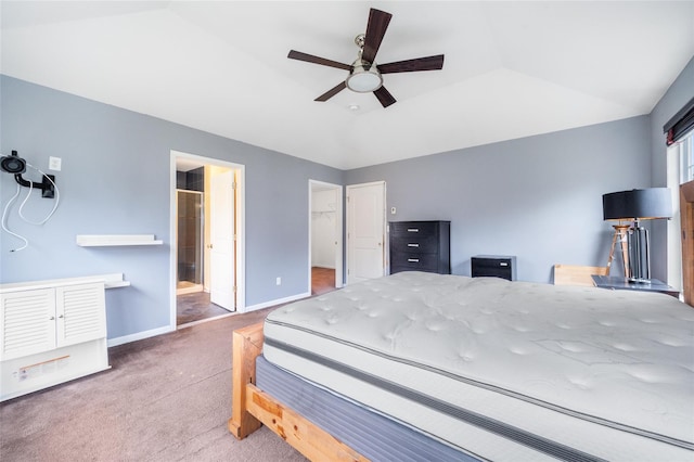 bedroom with carpet floors, ensuite bathroom, vaulted ceiling, and ceiling fan