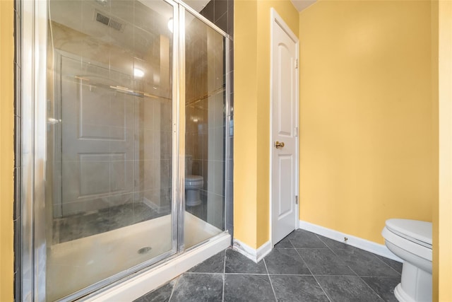 bathroom with tile patterned flooring, a shower with shower door, and toilet