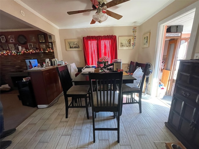 dining area featuring light hardwood / wood-style flooring, ceiling fan, and crown molding