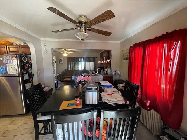 tiled dining room with radiator heating unit, ceiling fan, and ornamental molding