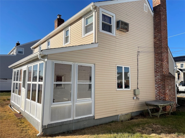 rear view of house featuring a sunroom