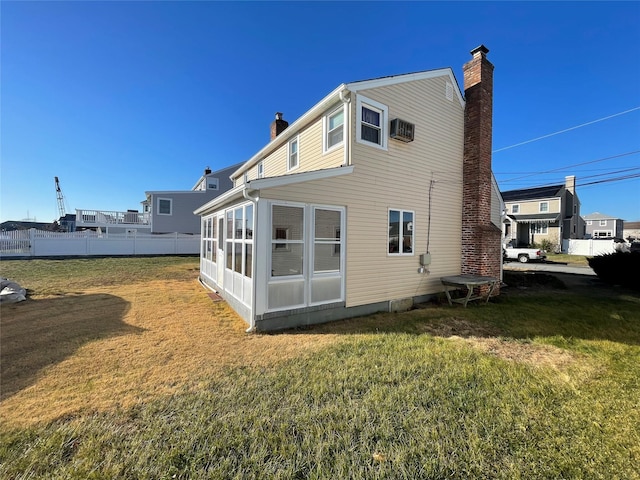 back of house with a sunroom and a yard