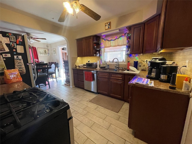 kitchen featuring sink, ceiling fan, appliances with stainless steel finishes, tasteful backsplash, and light hardwood / wood-style floors