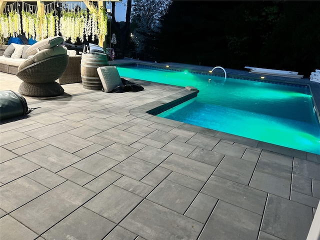 view of swimming pool featuring pool water feature, a patio, and an outdoor living space