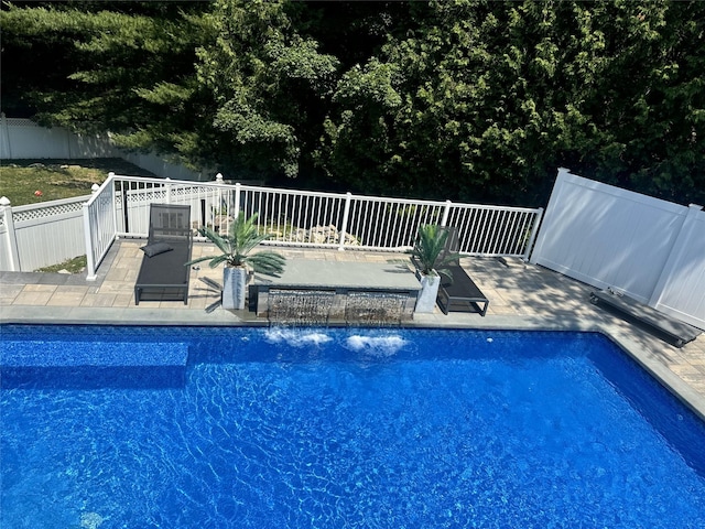 view of swimming pool with pool water feature and a patio