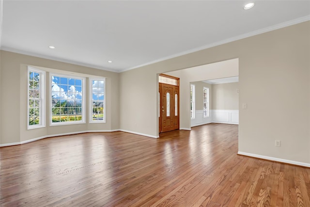 unfurnished living room featuring light hardwood / wood-style floors and ornamental molding