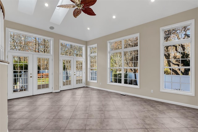 unfurnished sunroom featuring french doors, a skylight, and ceiling fan