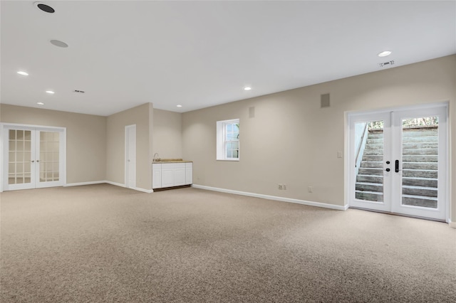 carpeted empty room with french doors and a healthy amount of sunlight