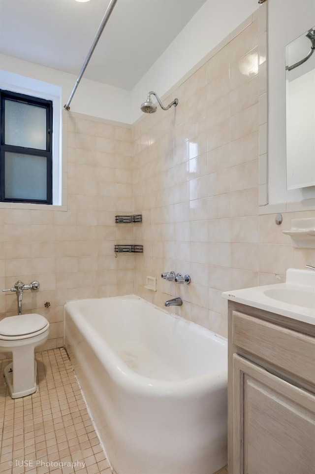 full bathroom with tiled shower / bath combo, tile patterned floors, toilet, vanity, and tile walls