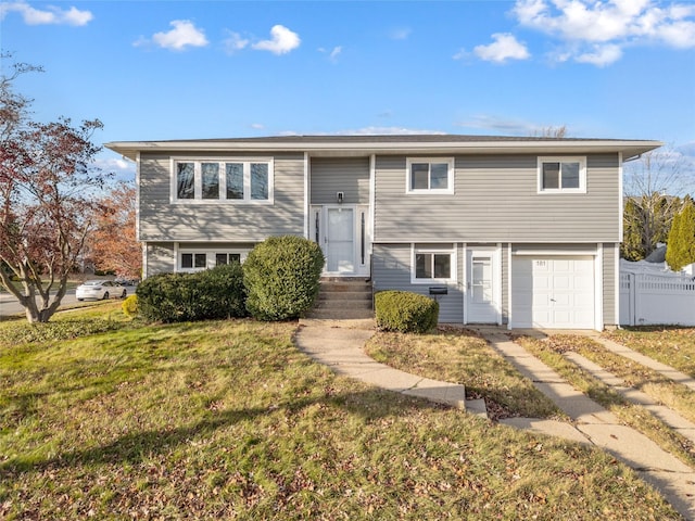 bi-level home with a front yard and a garage