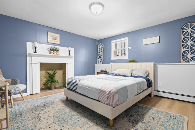 bedroom with hardwood / wood-style flooring and baseboard heating