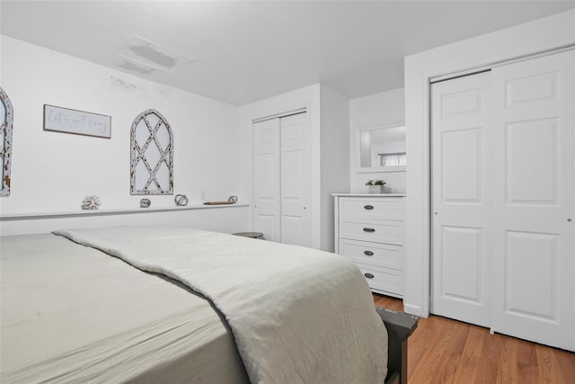 bedroom featuring multiple closets and hardwood / wood-style flooring