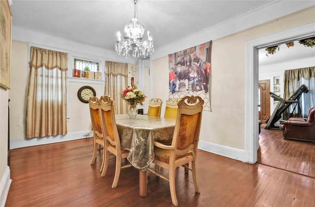 dining space with ornamental molding, hardwood / wood-style flooring, and a notable chandelier