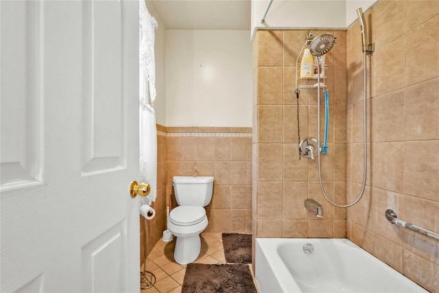 bathroom featuring tile patterned flooring, tiled shower / bath combo, toilet, and tile walls