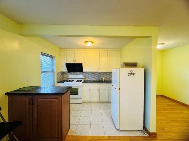 kitchen with white appliances, white cabinets, sink, light wood-type flooring, and tasteful backsplash