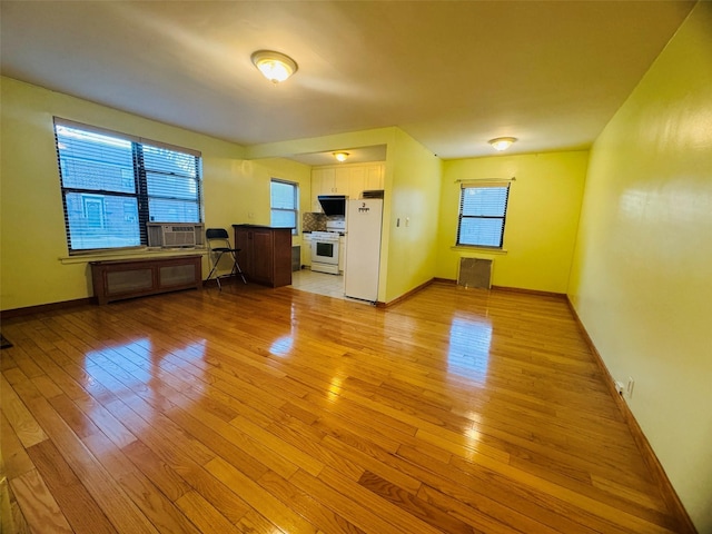 unfurnished living room featuring light hardwood / wood-style floors and cooling unit