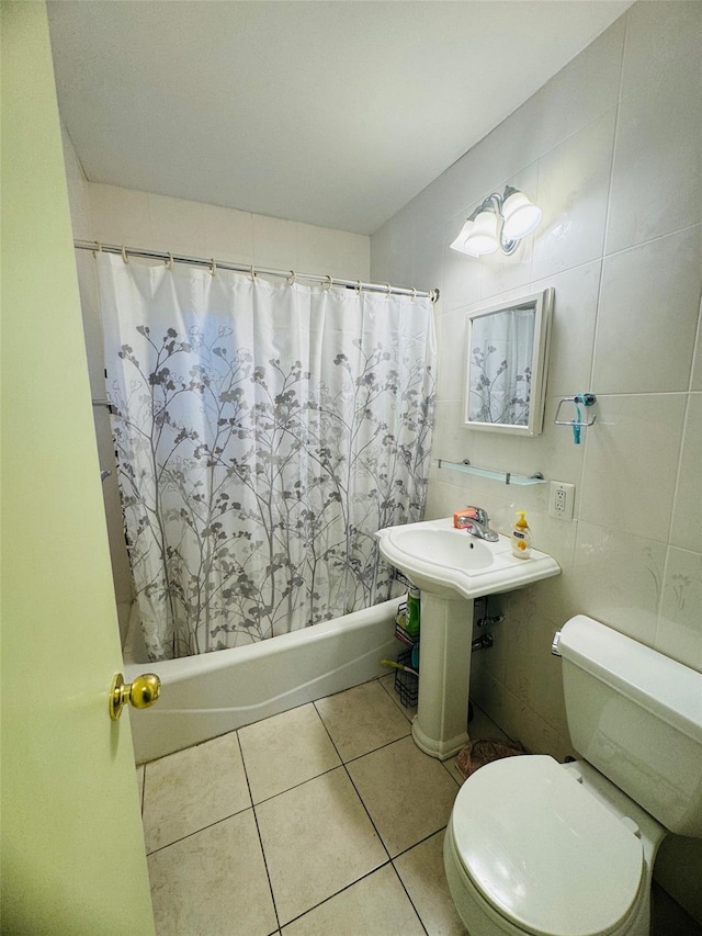 bathroom with tile patterned floors, shower / bathtub combination with curtain, tile walls, and toilet