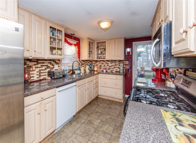 kitchen featuring stainless steel fridge, range with gas cooktop, sink, dishwasher, and hanging light fixtures