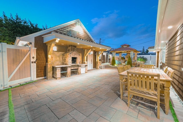 view of patio / terrace with a gazebo and an outdoor stone fireplace