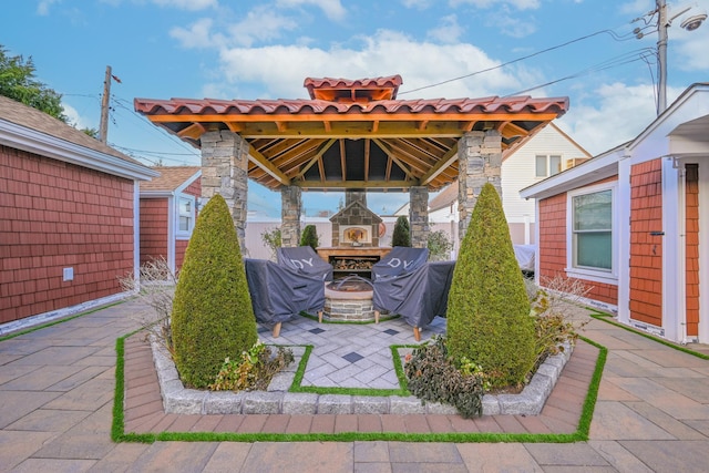 view of patio / terrace featuring a gazebo, area for grilling, and a fireplace