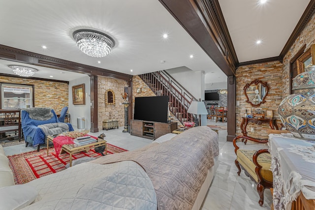 tiled living room featuring a fireplace, crown molding, and a notable chandelier