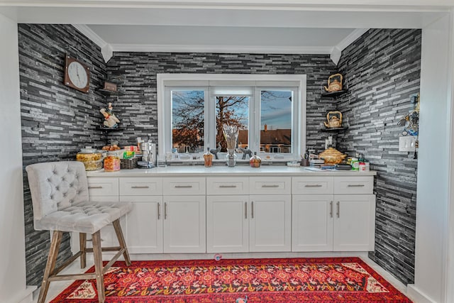 bar with white cabinetry and crown molding