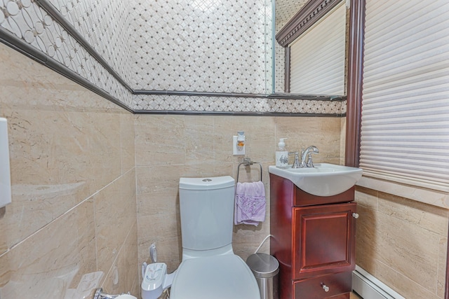 bathroom with vanity, a bidet, toilet, baseboard heating, and tile walls