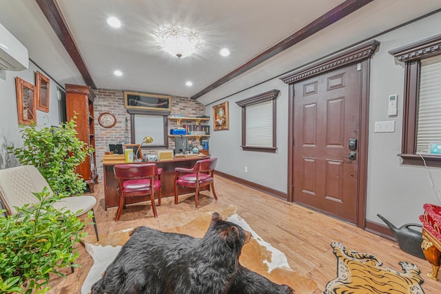 interior space with light hardwood / wood-style floors, a wall unit AC, and brick wall