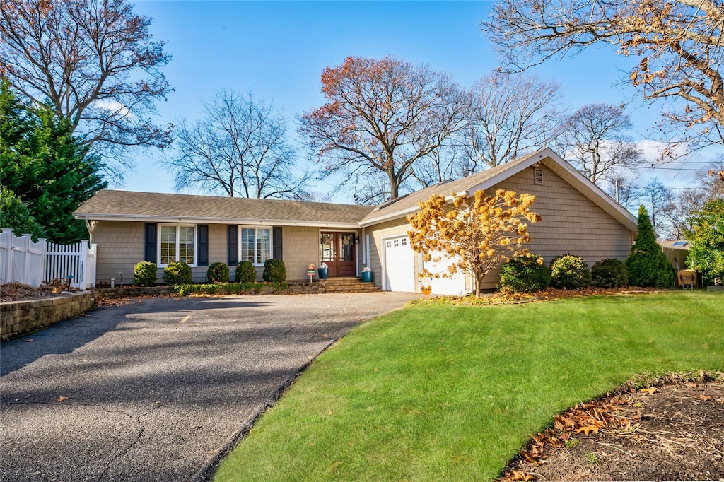 ranch-style house featuring a garage and a front yard