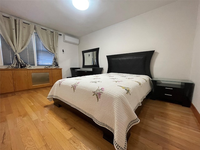 bedroom featuring light wood-type flooring and a wall mounted AC