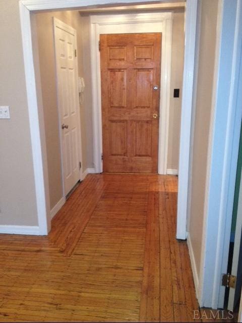 corridor with hardwood / wood-style flooring