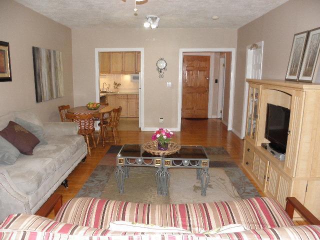 living room with sink, light wood-type flooring, and a textured ceiling