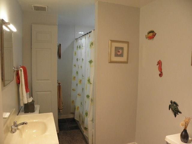 bathroom with shower / bath combo, vanity, and tile patterned floors