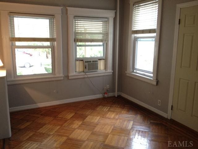 empty room featuring cooling unit and light parquet flooring