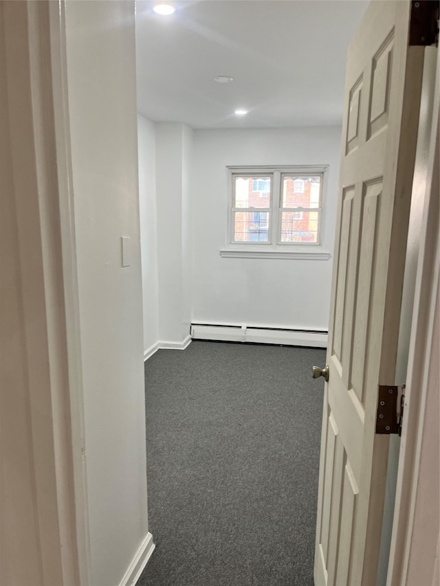 hallway with dark colored carpet and a baseboard radiator