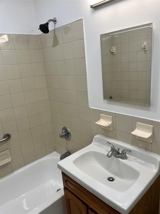 bathroom with vanity, tiled shower / bath combo, and tasteful backsplash