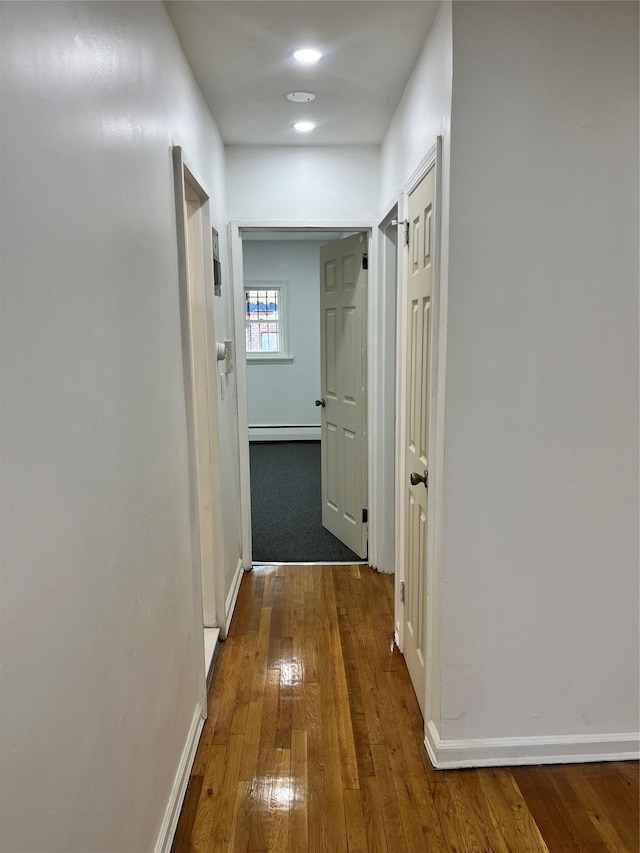 corridor featuring dark hardwood / wood-style floors and baseboard heating